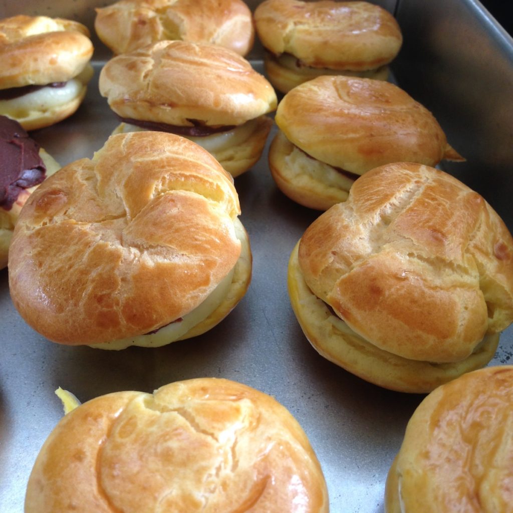 Homemade cream puffs with creme pat and chocolate ganache plus passionfruit jam